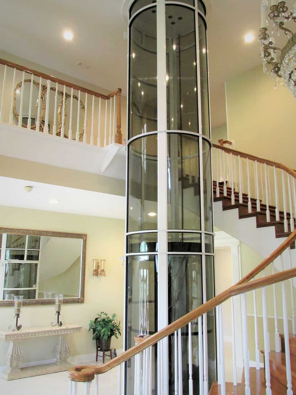 pneumatic vacuum elevator installed in the center of a winding staircase in a home