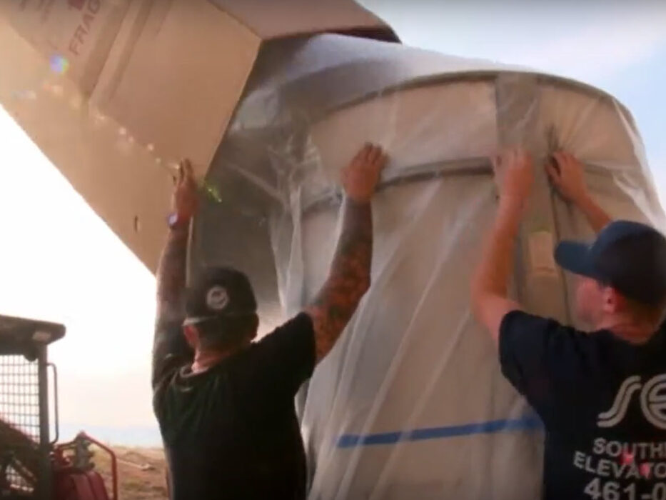 elevator installers unboxing a pre-built module of a shaftless elevator for a home